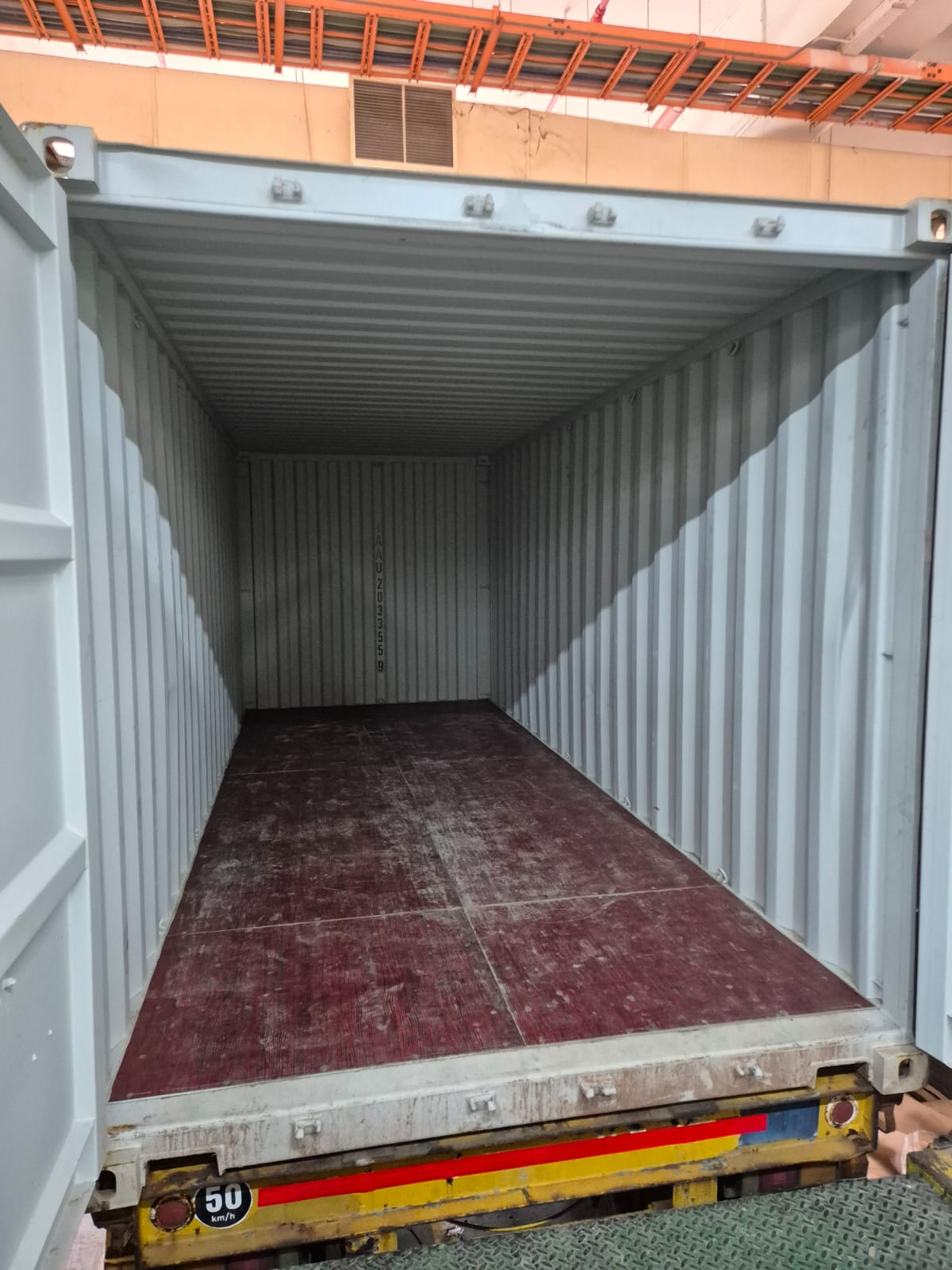The empty interior of an open shipping container on a trailer