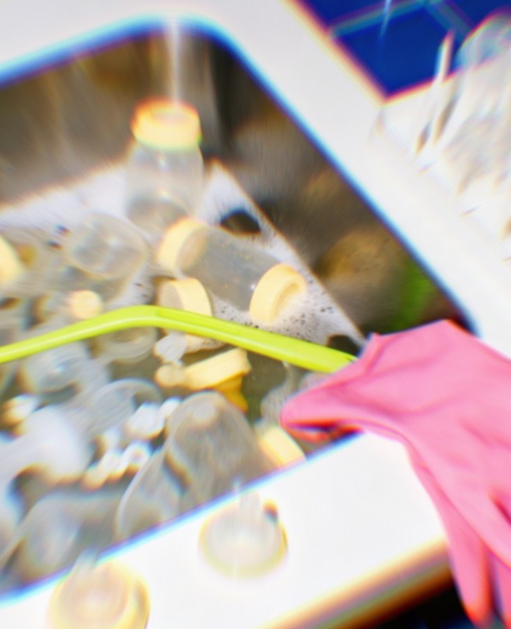 A blurred, cluttered sink full of bottle parts.